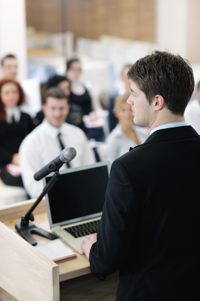 young  male business man giving a presentation at a  meeting seminar at modern conference room  on a table board